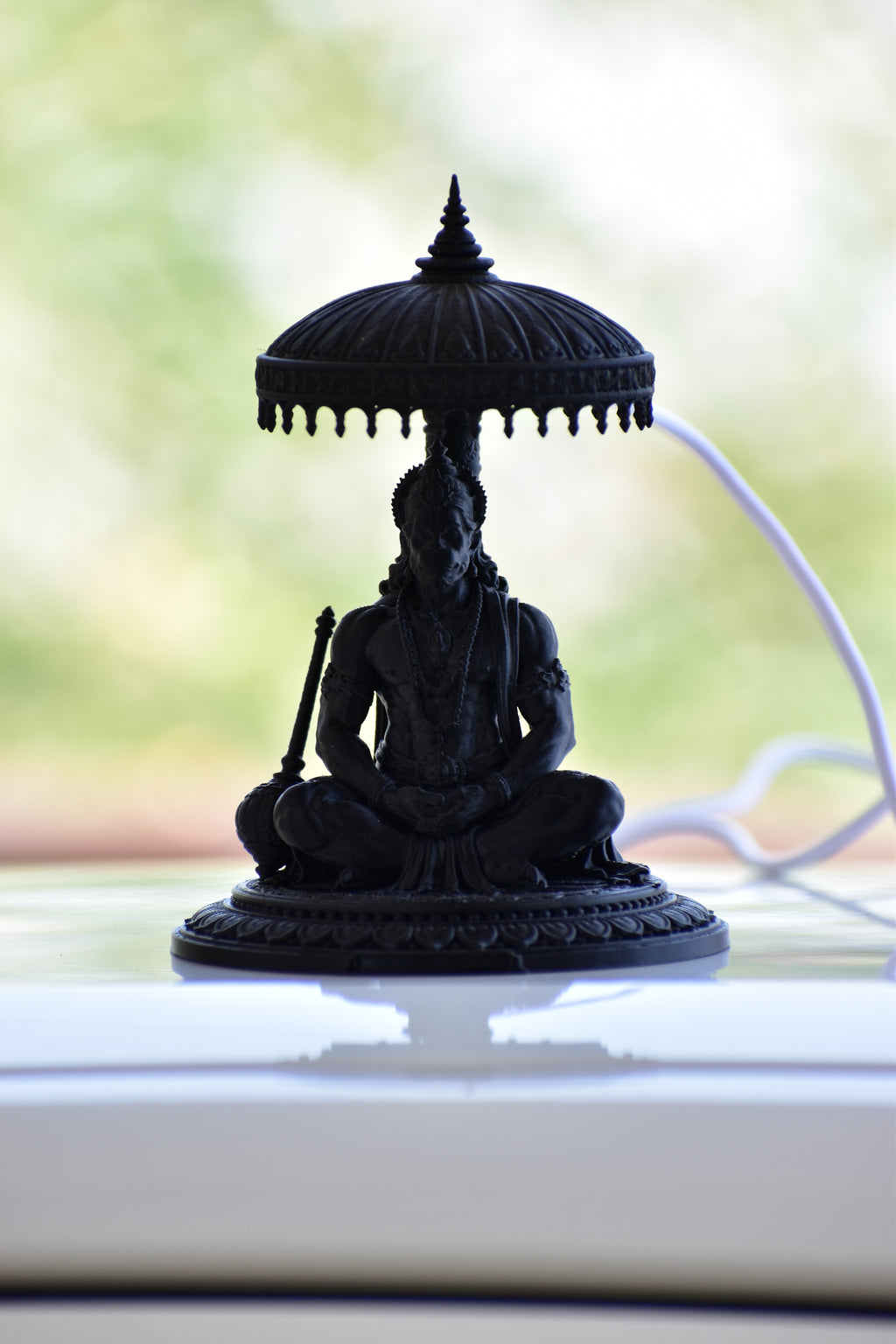 Black hanuman statue with a blurred background